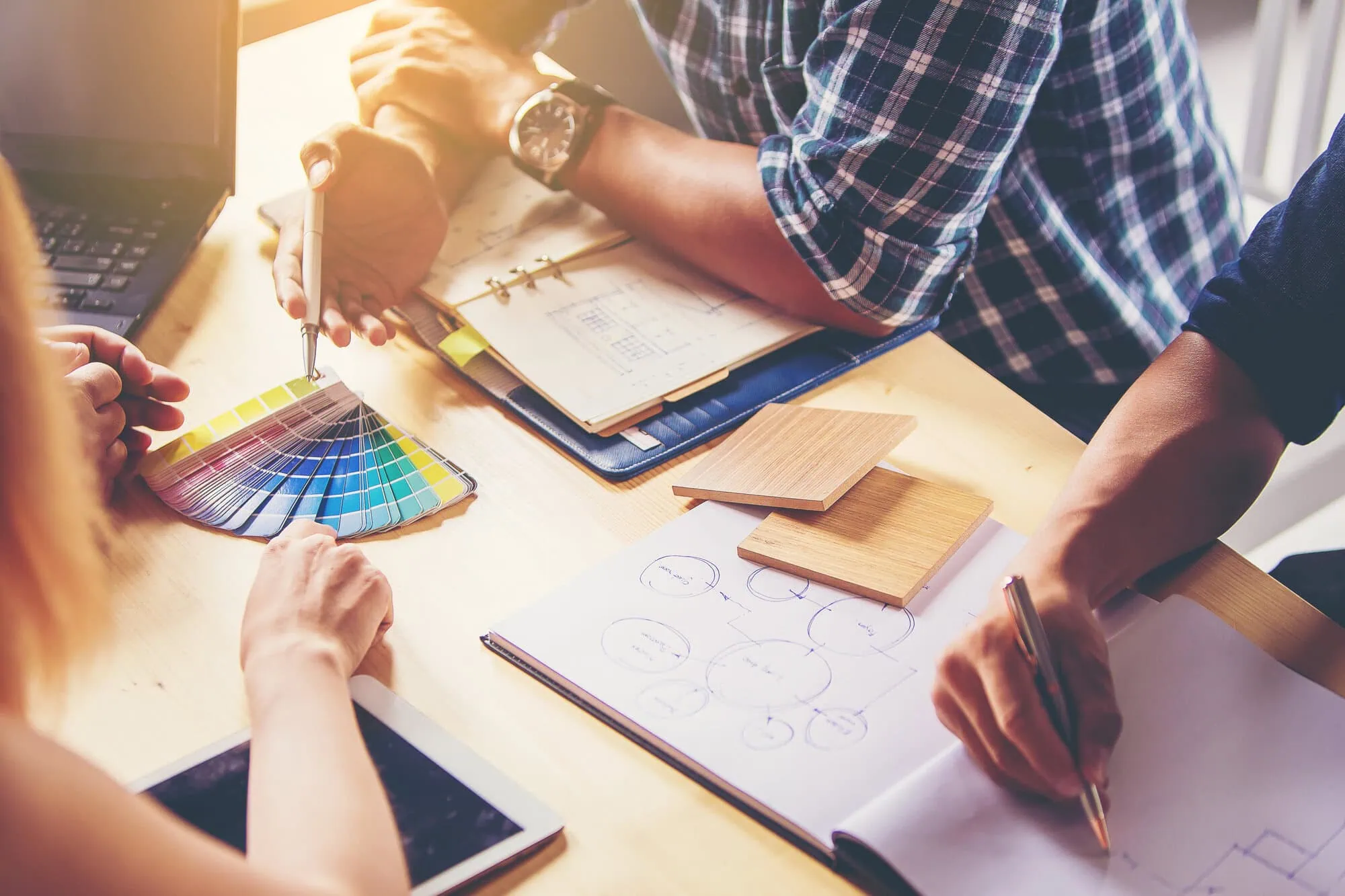 Creative professionals working around a table executing business graphic design services